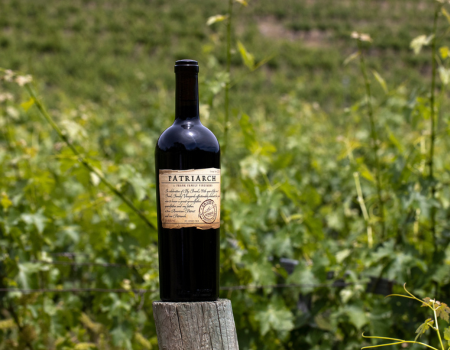 A bottle of Patriarch perched on a vineyard post at Winston Hill