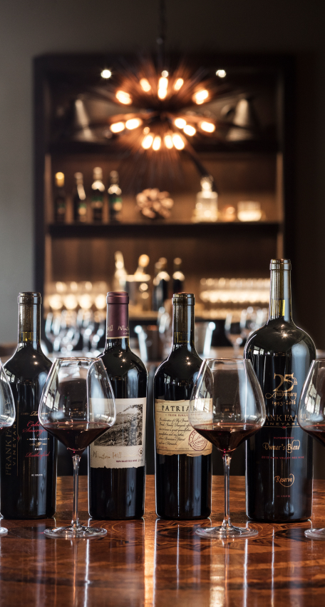 An assortment of wine bottles and glasses on a table.