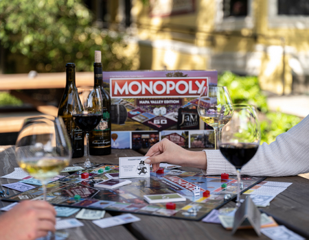 Friends enjoying Frank Family wine and playing the Monopoly Napa Valley Edition game board 
