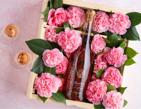 A bottle of Frank Family's Brut Rosé in a box of pink flowers