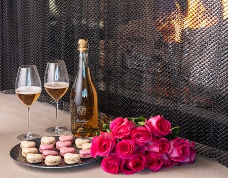 A bottle of Frank Family's Brut Rosé with two wine glasses and heart shaped cookies