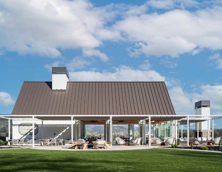 White barn-like building with lawn, fire pit, and outdoor furniture