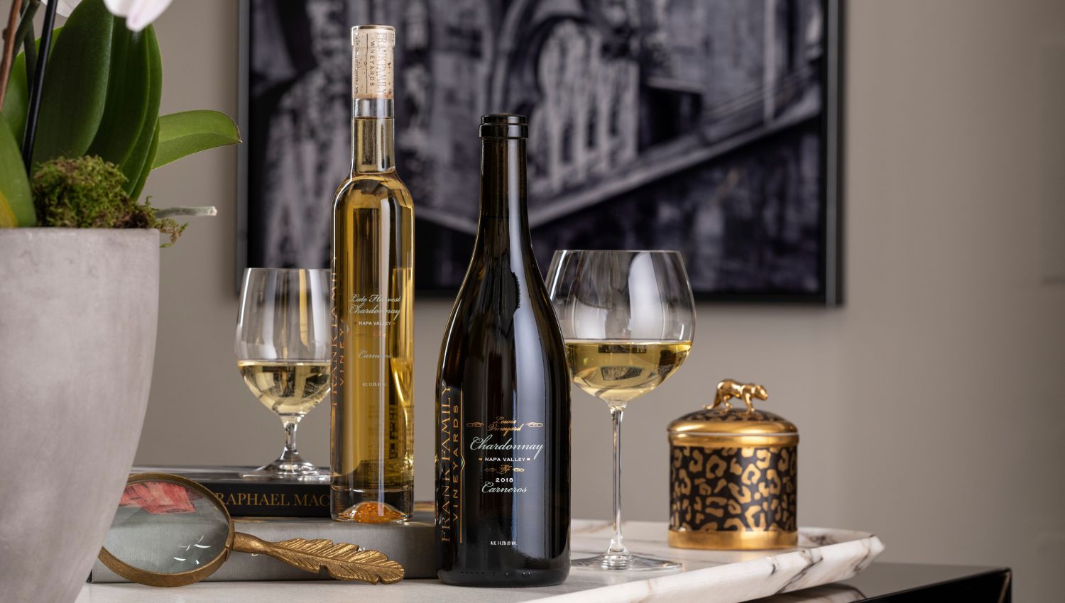 A bottle of Lewis Vineyard Chardonnay and Late Harvest Chardonnay in front of a printed photograph of the Milan Duomo
