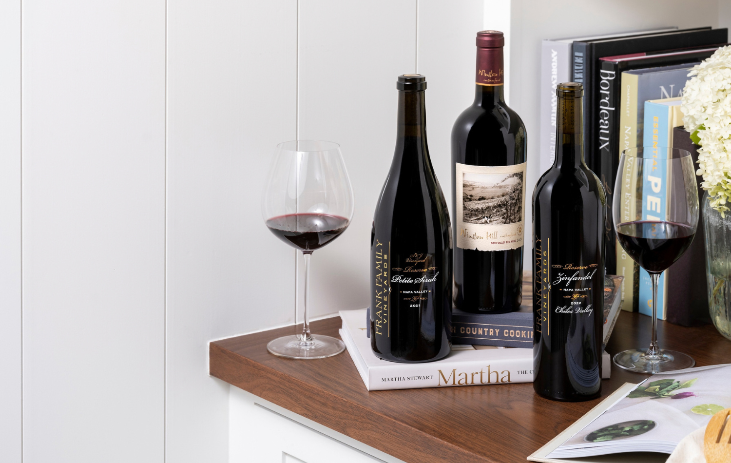 Three bottles of Reserve wine set against a backdrop of cook books. 