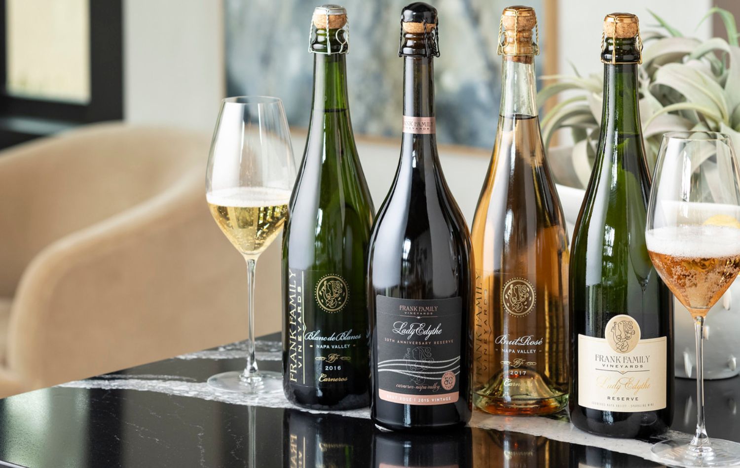 An assortment of Frank Family sparkling wines set on a coffee table with books and decor